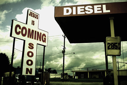 dingy depressing old gas station with a jesus cross saying "jesus is coming soon"